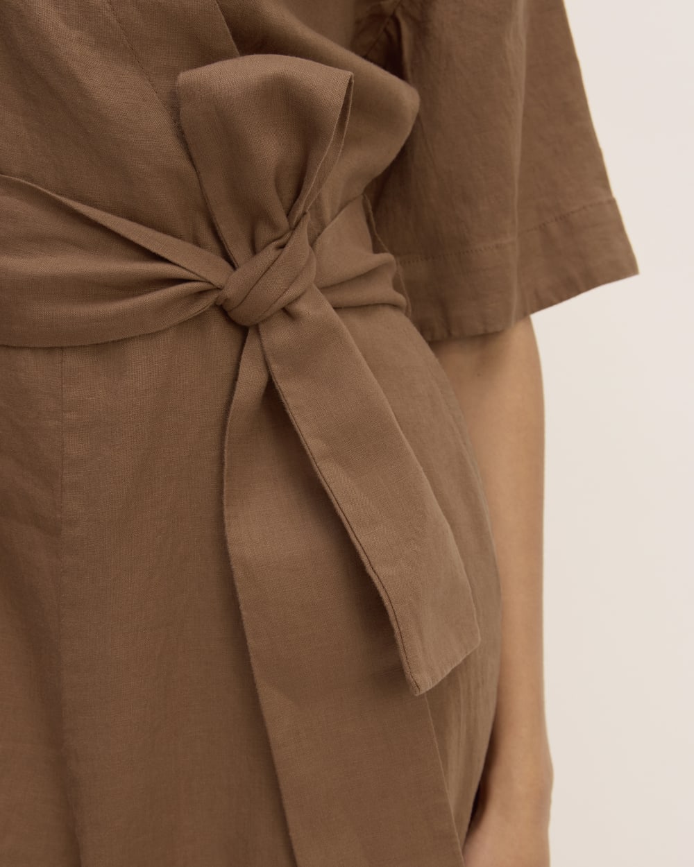 The Wrap Jumpsuit in Linen in Carob Brown — detail view