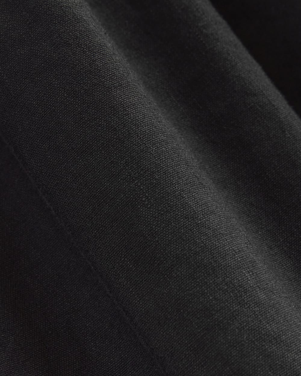 The Flutter-Sleeve Dress in Stretch Linen in Black — detail view