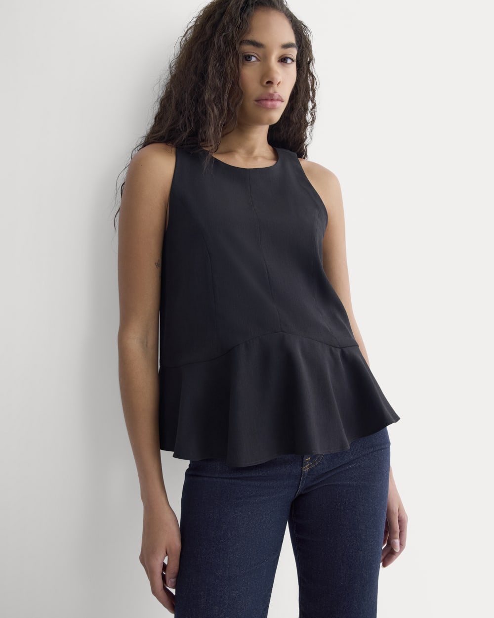 Sleeveless Peplum Top in Black — front view